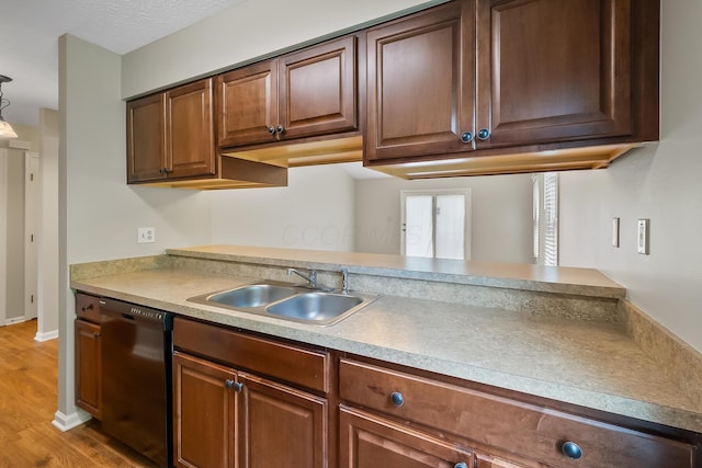 kitchen with dishwasher, sink, hanging light fixtures, and light wood-type flooring