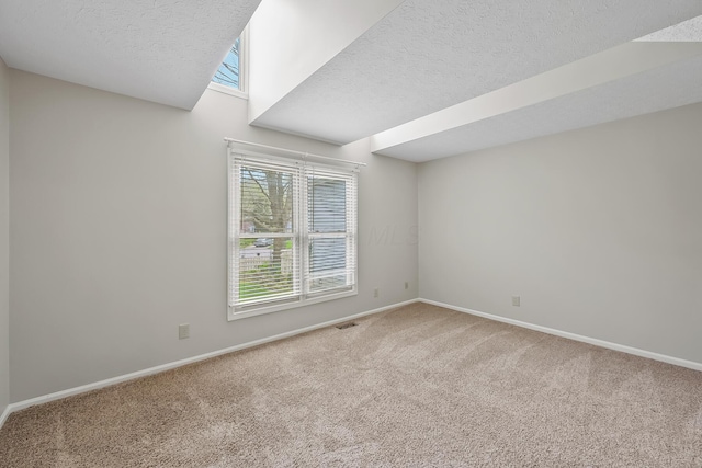 carpeted empty room with a textured ceiling