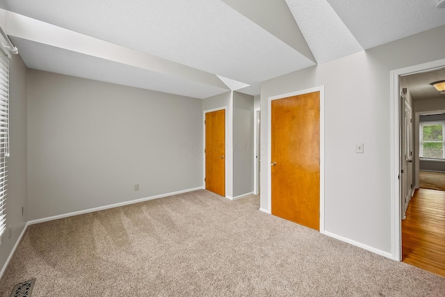 empty room featuring light colored carpet and a textured ceiling