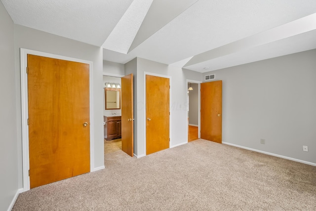 unfurnished bedroom featuring light colored carpet and a textured ceiling