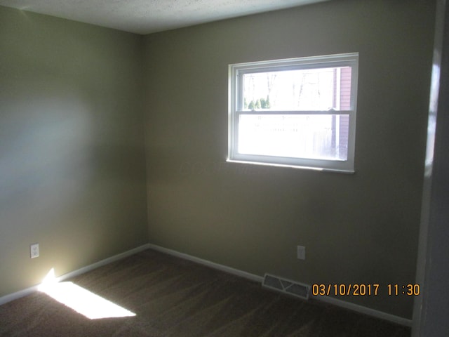 empty room featuring dark colored carpet