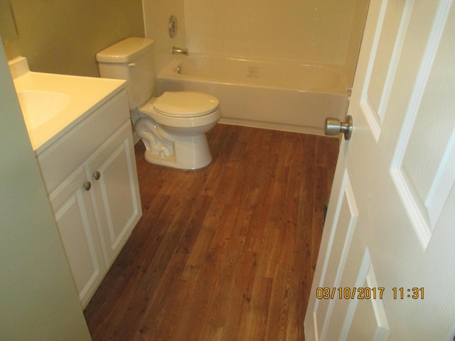 full bathroom with vanity, hardwood / wood-style floors, shower / bathing tub combination, and toilet