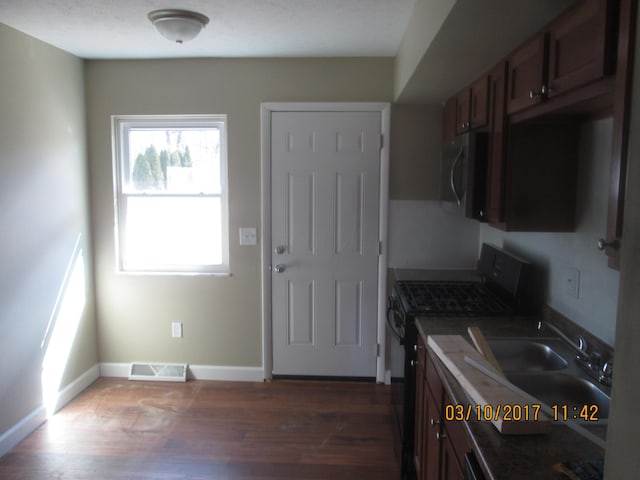 kitchen with sink, range with gas stovetop, and dark hardwood / wood-style floors