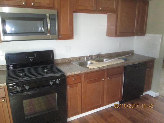 kitchen featuring sink, dark wood-type flooring, and black appliances