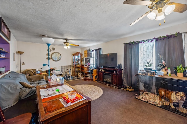 living room with ceiling fan, dark carpet, and a textured ceiling