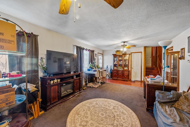 living room with carpet floors, a textured ceiling, and ceiling fan