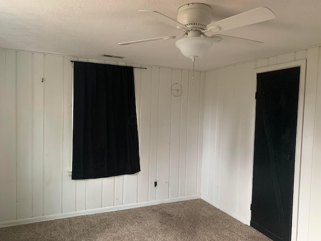 carpeted empty room featuring a textured ceiling and ceiling fan