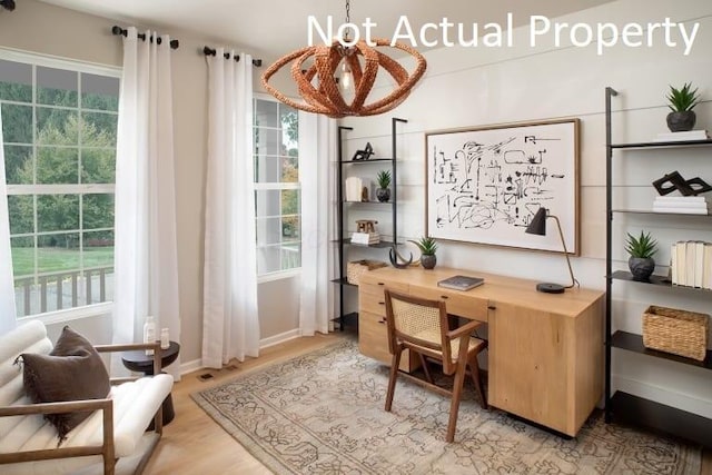 office area with light hardwood / wood-style flooring and an inviting chandelier