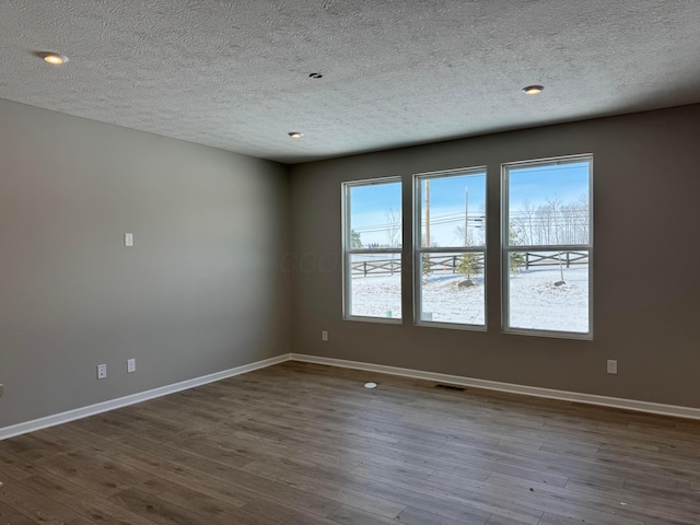 empty room featuring hardwood / wood-style flooring and a textured ceiling