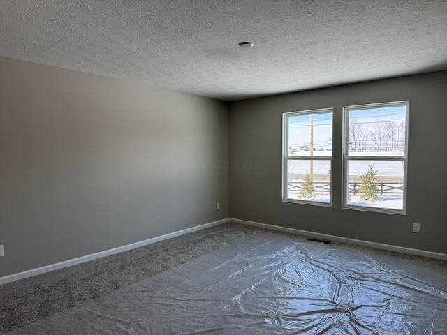 carpeted spare room featuring a textured ceiling