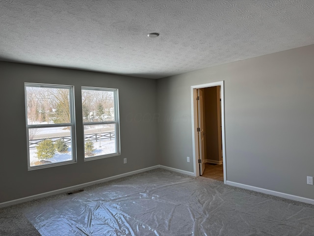 spare room with a textured ceiling