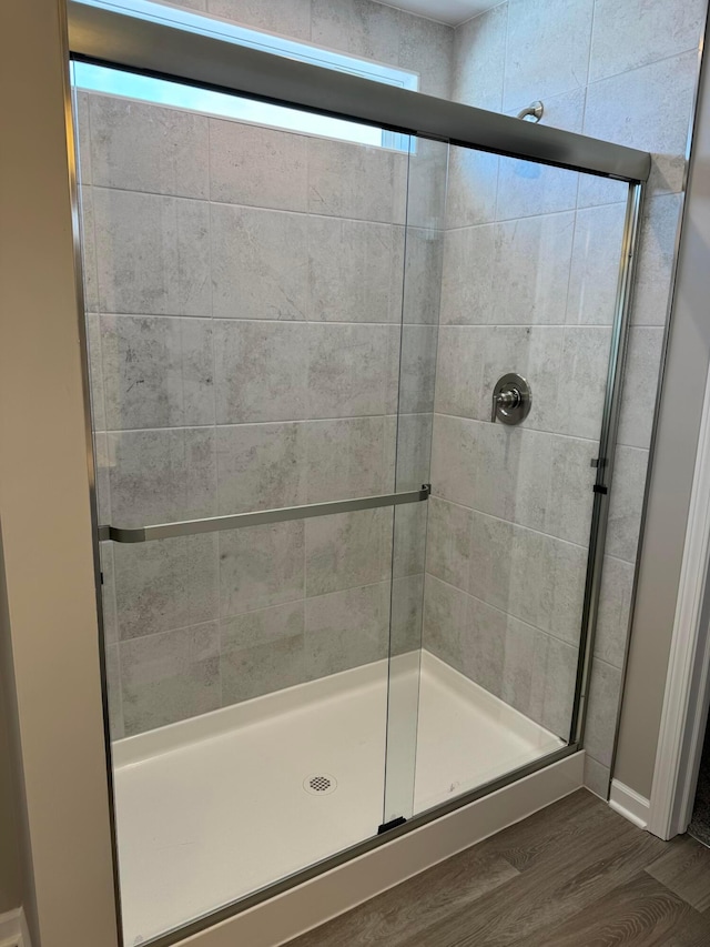 bathroom featuring hardwood / wood-style flooring and walk in shower