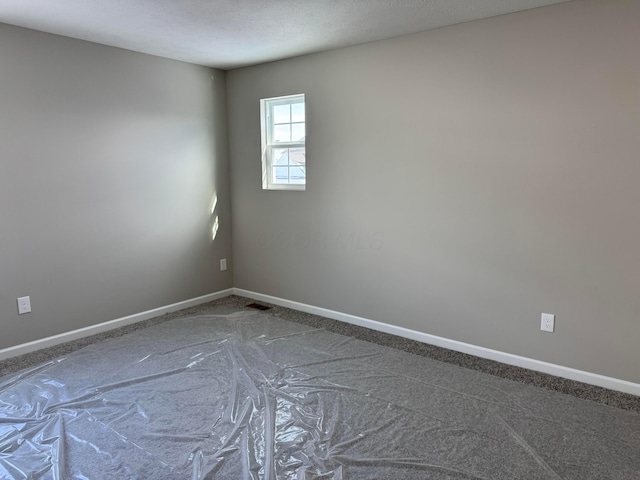 empty room with a textured ceiling and carpet flooring