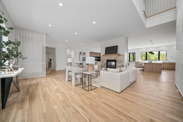 living area with a multi sided fireplace, light wood-style flooring, and recessed lighting