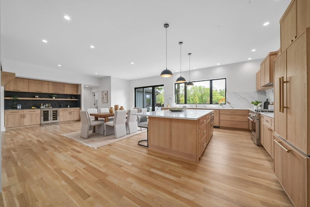 kitchen with wine cooler, recessed lighting, high end stainless steel range oven, light countertops, and backsplash