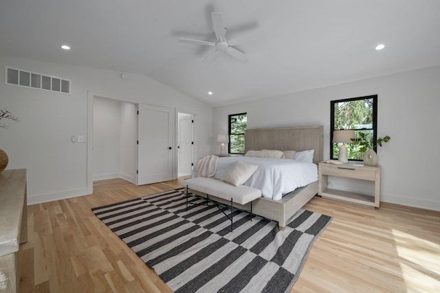 bedroom featuring vaulted ceiling, light wood-type flooring, visible vents, and multiple windows