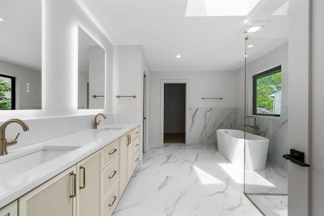 bathroom with a wainscoted wall, a soaking tub, double vanity, and a sink