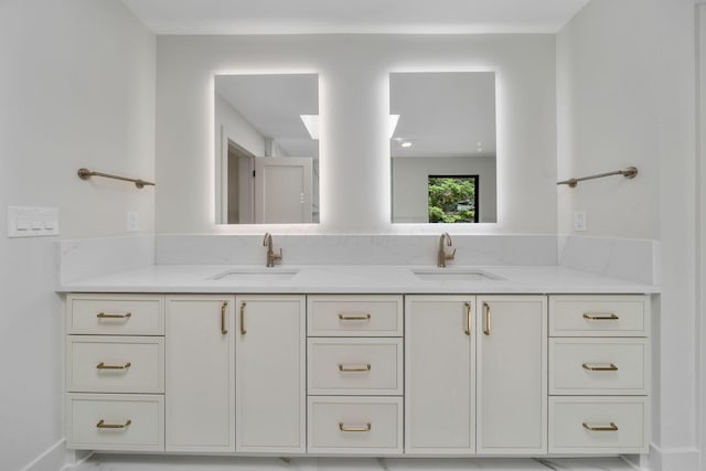 full bathroom with double vanity and a sink