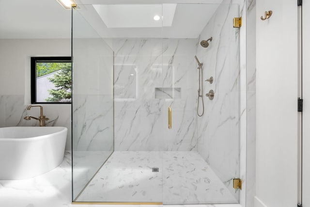 full bathroom featuring a marble finish shower and a freestanding tub