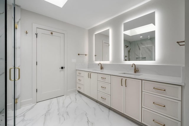 bathroom featuring a marble finish shower, marble finish floor, double vanity, and a sink