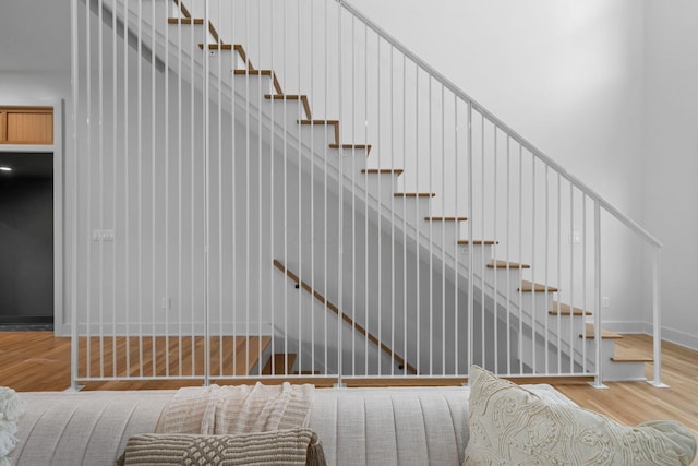 staircase with baseboards and wood finished floors