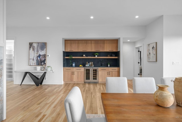 dining area with wine cooler, recessed lighting, baseboards, light wood finished floors, and wet bar
