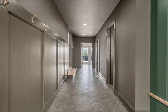 corridor with baseboards, tile patterned floors, and recessed lighting