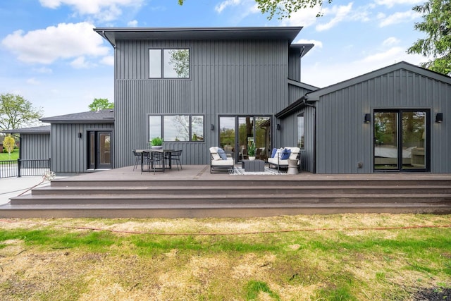 rear view of house with a deck and an outdoor living space