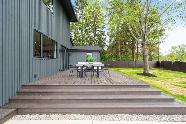 deck with a lawn, outdoor dining area, and a fenced backyard