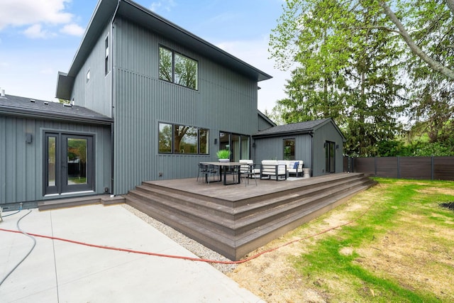 back of property with a deck, a patio area, outdoor dining area, and fence