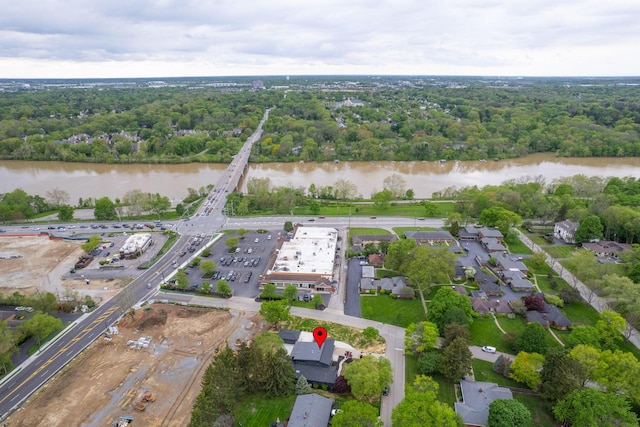 birds eye view of property featuring a forest view and a water view