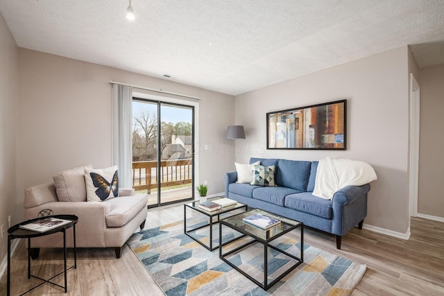 living room with light hardwood / wood-style flooring and a textured ceiling