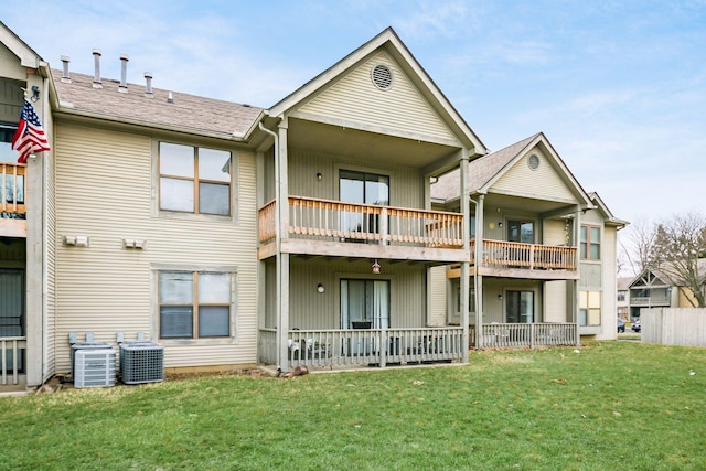 rear view of property featuring a balcony, a lawn, and central air condition unit