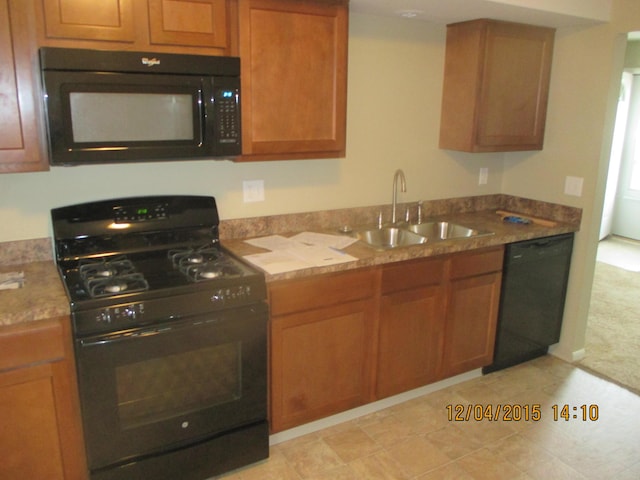 kitchen with sink, black appliances, and light stone countertops