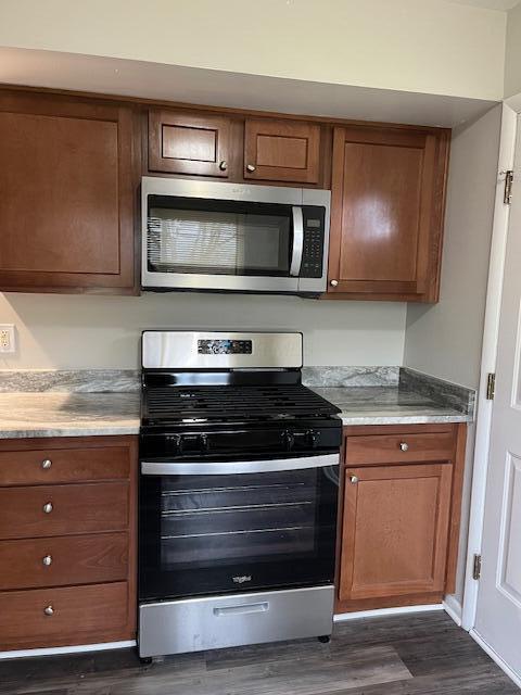 kitchen with dark hardwood / wood-style flooring and appliances with stainless steel finishes