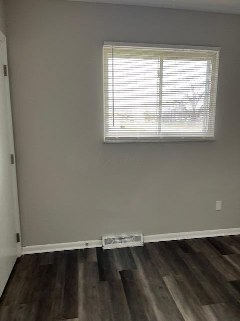 empty room featuring dark wood-type flooring