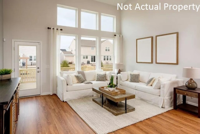 living room featuring hardwood / wood-style flooring, a high ceiling, and a wealth of natural light