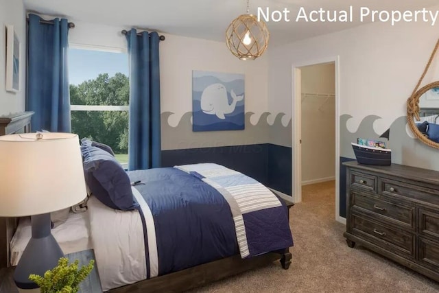 bedroom featuring a closet, a spacious closet, and light carpet