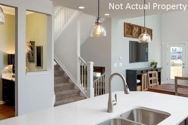 kitchen with light countertops, pendant lighting, recessed lighting, and a sink