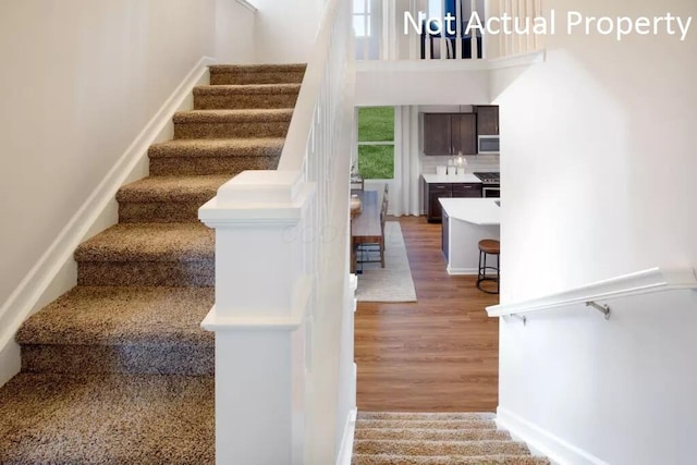 staircase with wood finished floors and baseboards