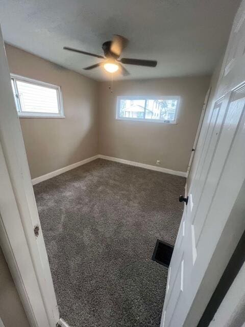 unfurnished bedroom featuring dark carpet and ceiling fan