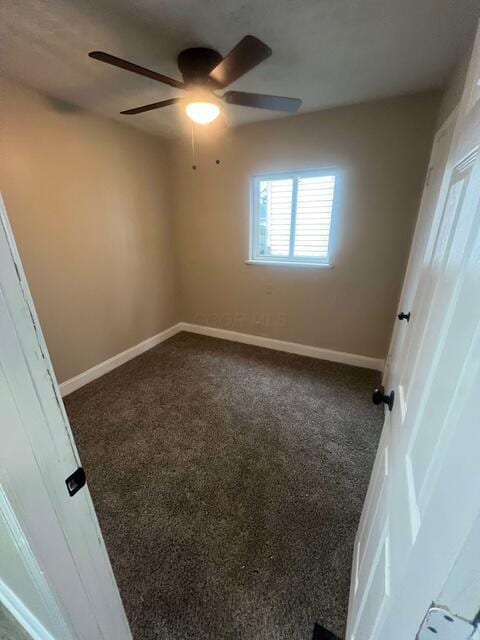 unfurnished room with dark colored carpet