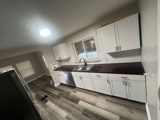 kitchen featuring dishwasher, white cabinetry, and sink