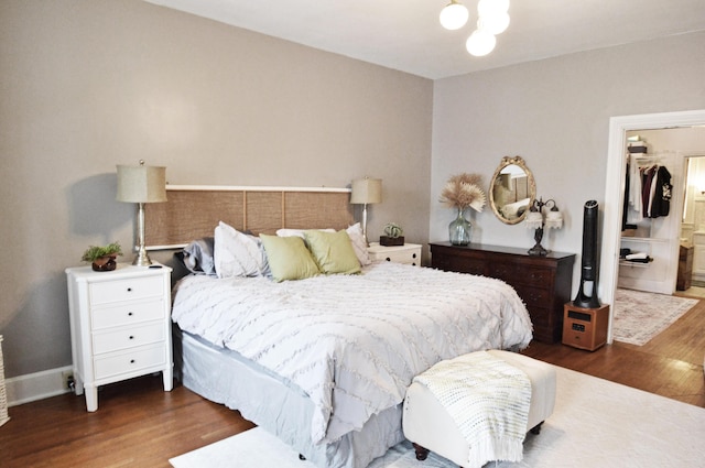 bedroom with a walk in closet, dark hardwood / wood-style flooring, and a closet