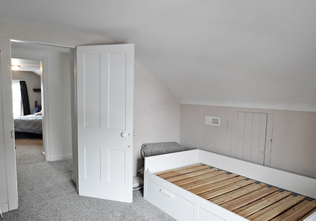 unfurnished bedroom featuring lofted ceiling and light carpet