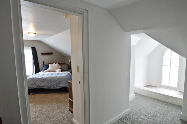 bedroom featuring light colored carpet and vaulted ceiling