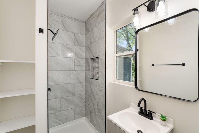 bathroom with vanity and a tile shower