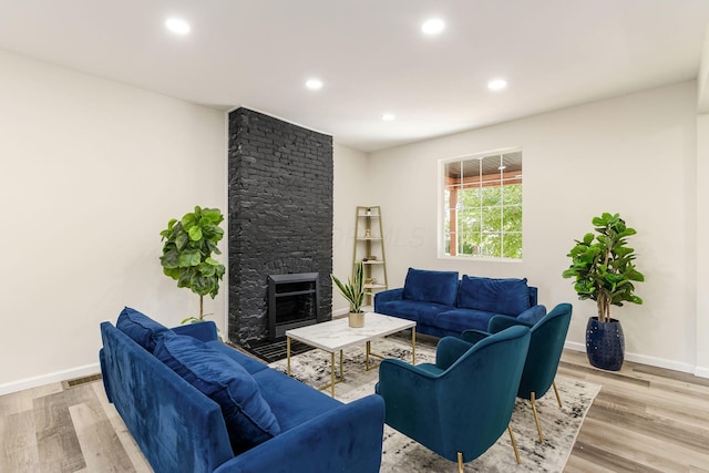 living room with a fireplace and light hardwood / wood-style flooring