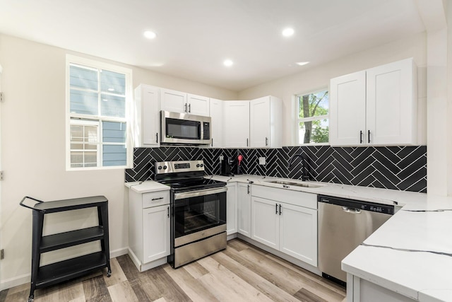 kitchen featuring white cabinetry, stainless steel appliances, sink, and decorative backsplash