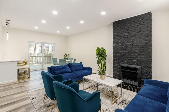 living room featuring a fireplace and light wood-type flooring